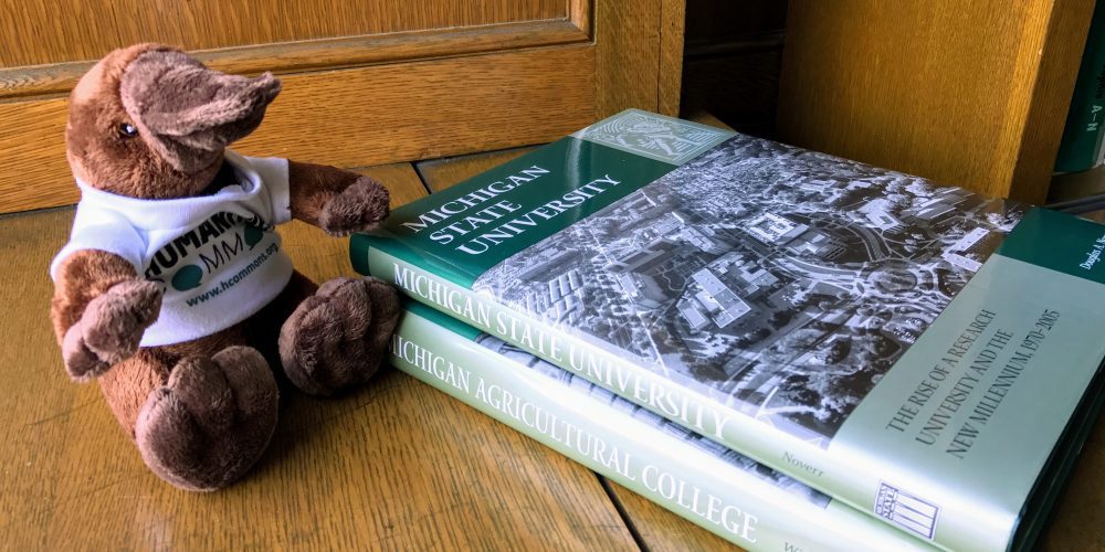A toy platypus and books about the history of MSU
